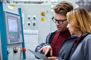 Auto-Ingenieure mit Tablet-PC vor Control Panel