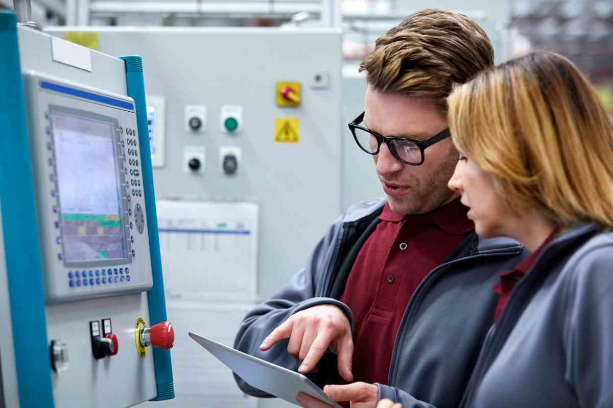 Auto-Ingenieure mit Tablet-PC vor Control Panel