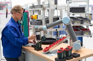 Kollaborative Bohrmaschinenmontage: eine Frau montiert in Zusammenarbeit mit einem Roboterarm eine Bohrmaschine.