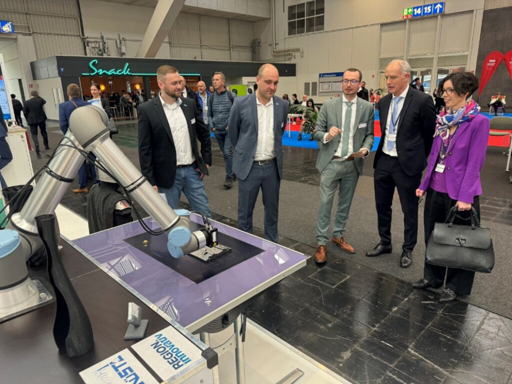 Forschende und Besucher auf der Hannover Messe sprechen über Mensch-Roboter Kollaboration und sehen einen Roboter in Aktion.