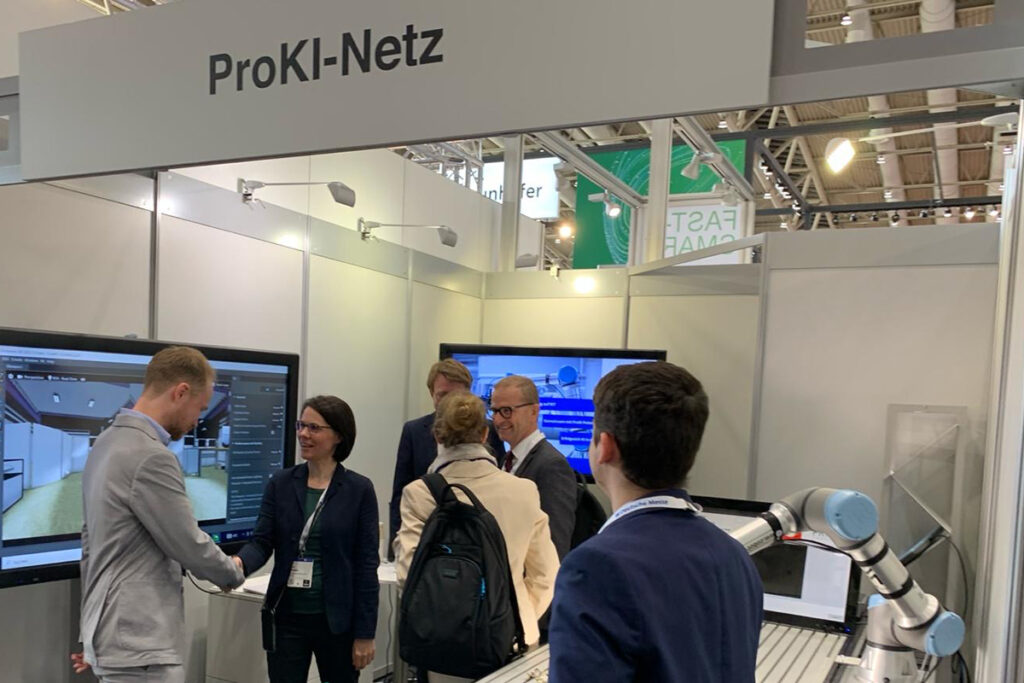 Frau Dr. Klüwer, Abteilungsleiterin des BMBF, im Gespräch mit Forschenden am Stand des Forschungsnetzwerks ProKI auf der Hannover Messe.