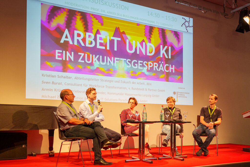Die Diskussions-Teilnehmenden auf der Bühne bei der Podiumsdisskussion zum Thema „Arbeit und KI“