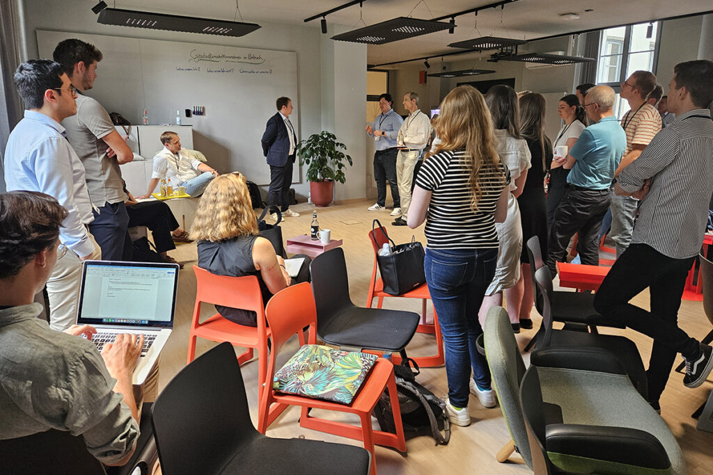 Austausch beim Kick-off des DaWeNa-HUB: Teilnehmende stehen und sitzen bei einem offenen Workshop-Format und diskutieren.