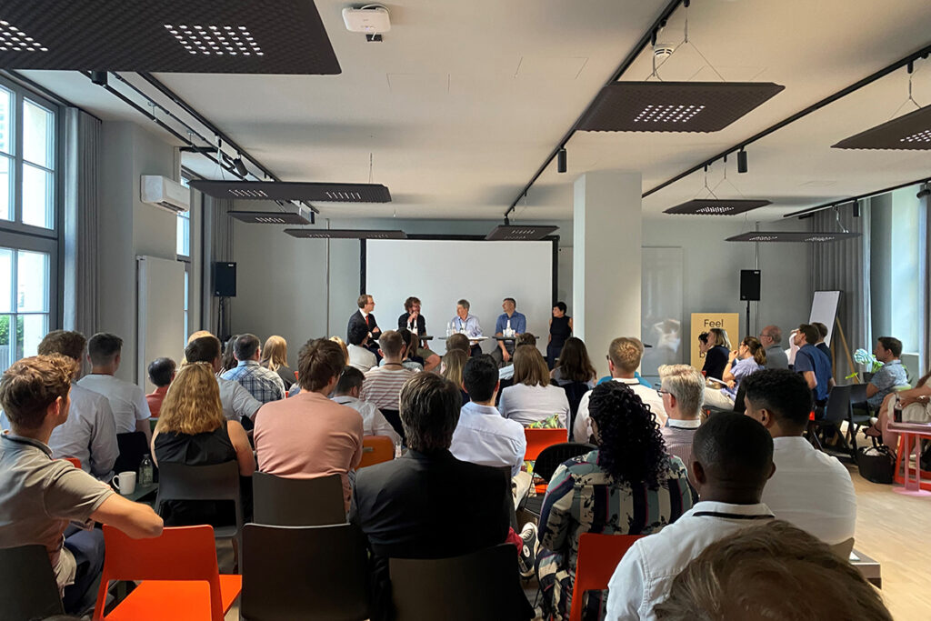 DaWeNa-HUB Kick-off Podiumsdiskussion: Vier Gäste auf der Bühne und das interessierte Publikum hört aufmerksam zu.