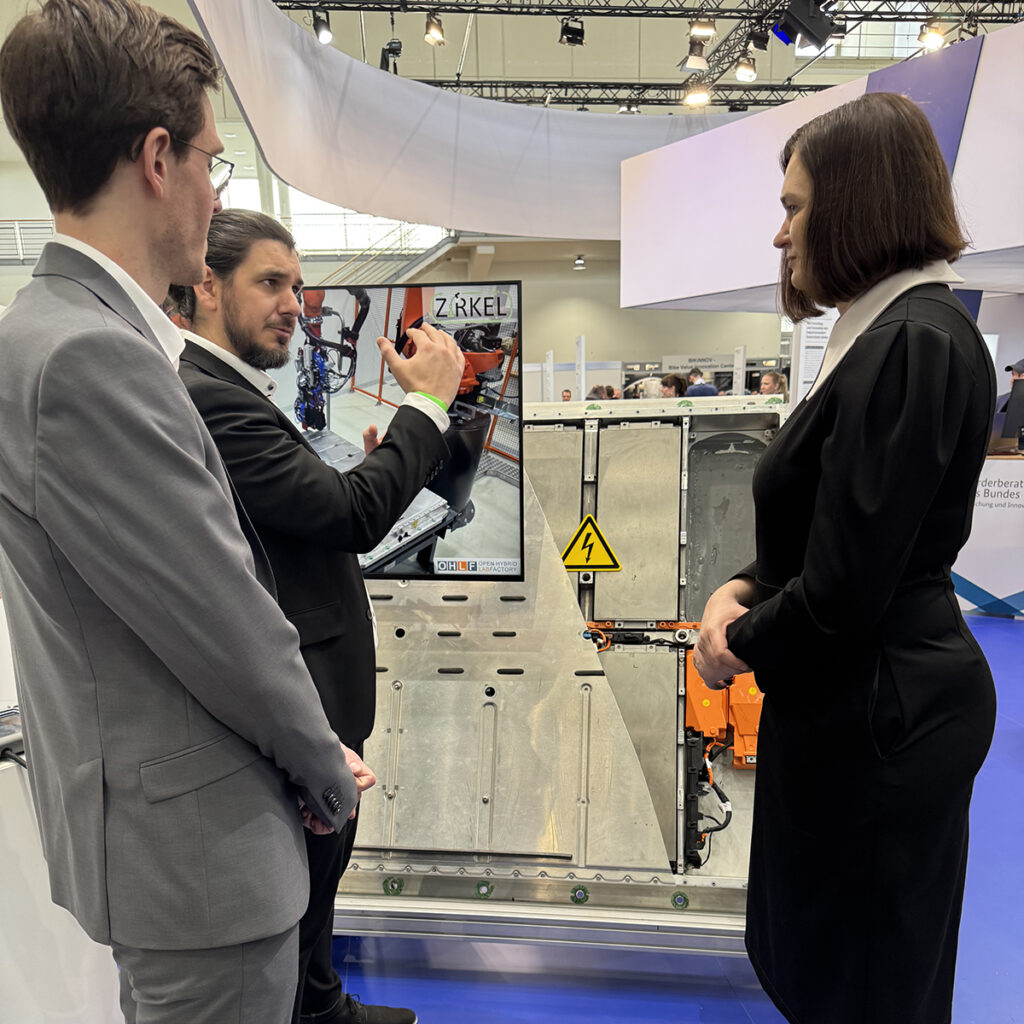 Bei ihrem Standrundgang nimmt sich die parlamentarische Staatssekretärin Claudia Müller Zeit für intensive Gespräche mit den Ausstellenden. Die Forschenden des Projekts ZIRKEL zeigen auf, wie Ressourcen besser genutzt werden können, indem Materialkreisläufe geschlossen werden. © PTKA