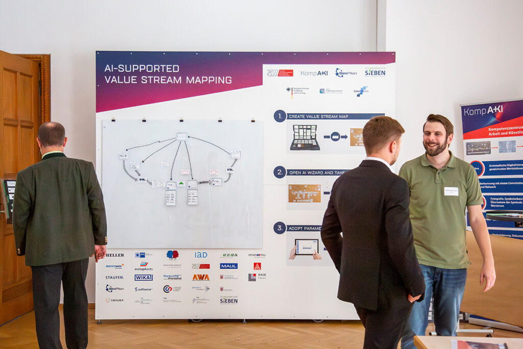 Marktplatz der Ideen. Projektbeteiligte und Teilnehmende der KompAKI Abschlussveranstaltung tauschen sich persönlich aus.