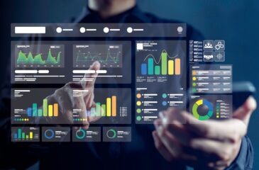 Bild der Bekanntmachung „KI-Module für Schlüsselfähigkeiten in Handwerk, Handel und Industrie (ModuS-KI)“. Gezeigt wird ein Mann, der einen projizierten Anzeige von Diagrammen und Schaubildern mit Berührung seiner Finger bedient.